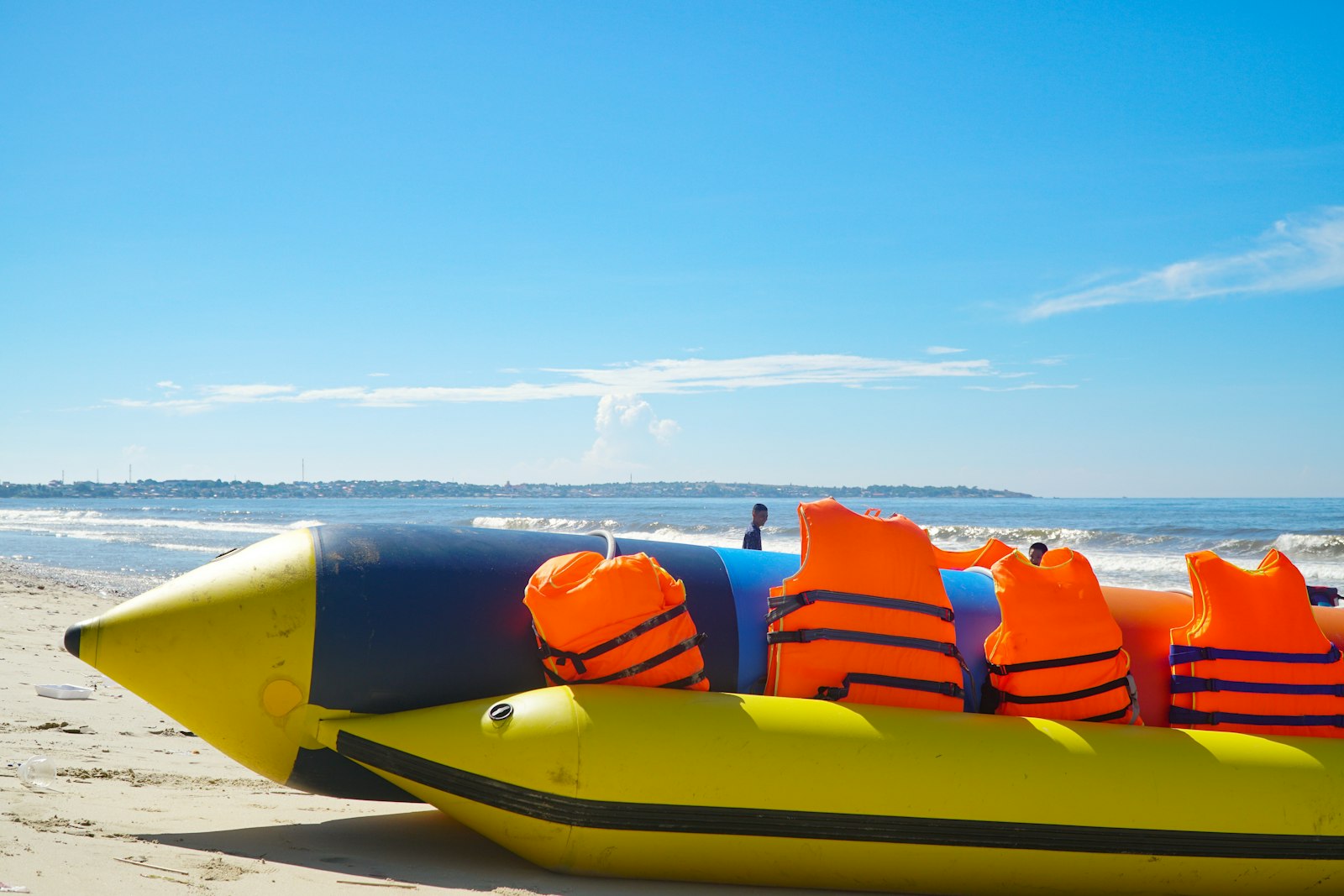 Yellow banana boat with life vests ready on the sand