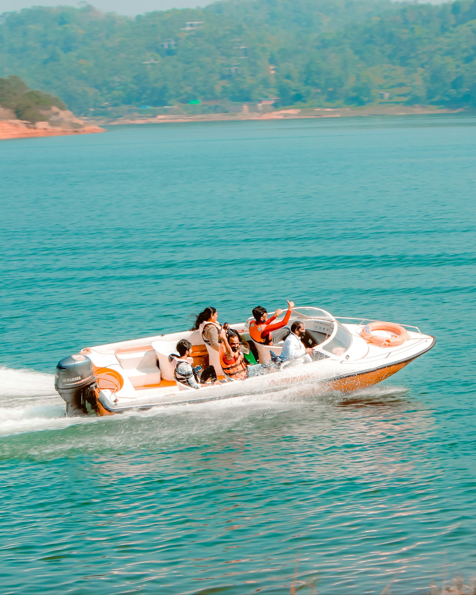 Guests enjoying a speedboat ride on clear turquoise water
