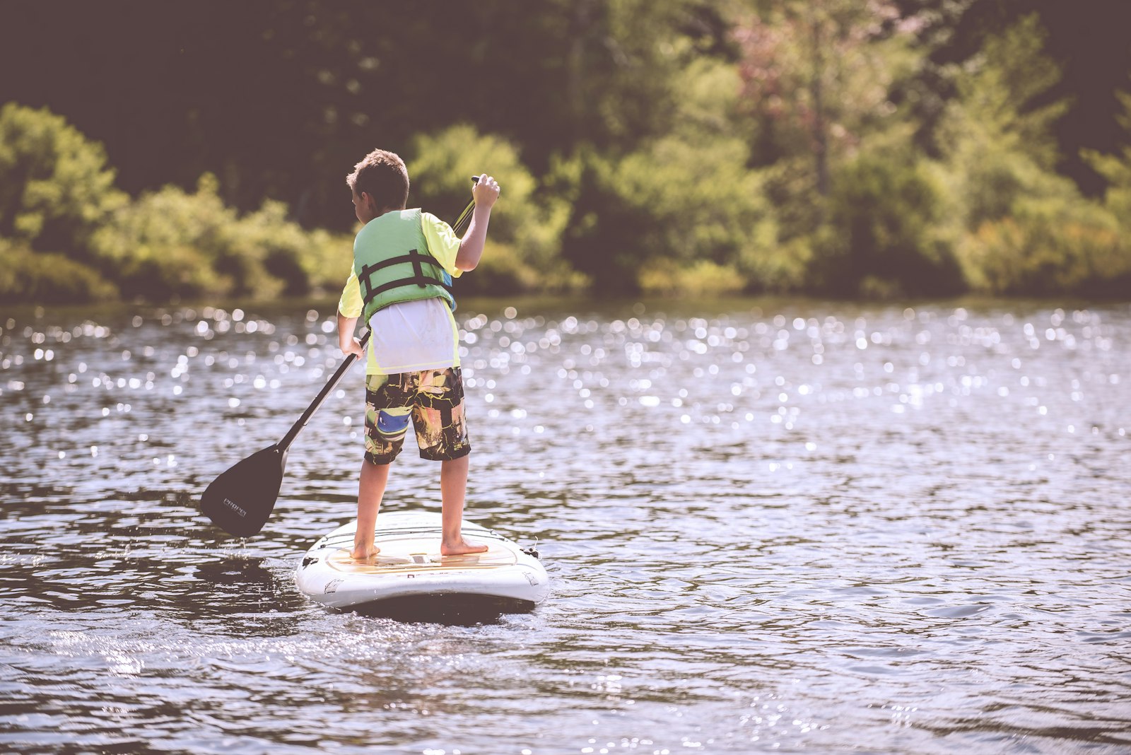 Paddleboarder on calm morning water