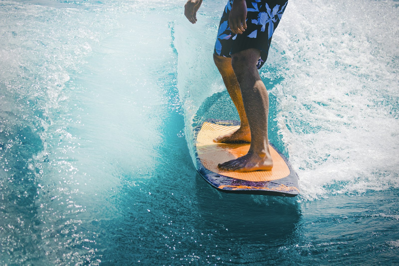 Feet on a surfboard in clear water